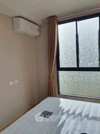 Cozy bedroom with air conditioning and large window with floral frosted glass for privacy.