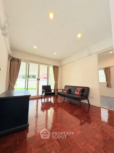 Spacious living room with elegant wooden flooring and large windows for natural light.