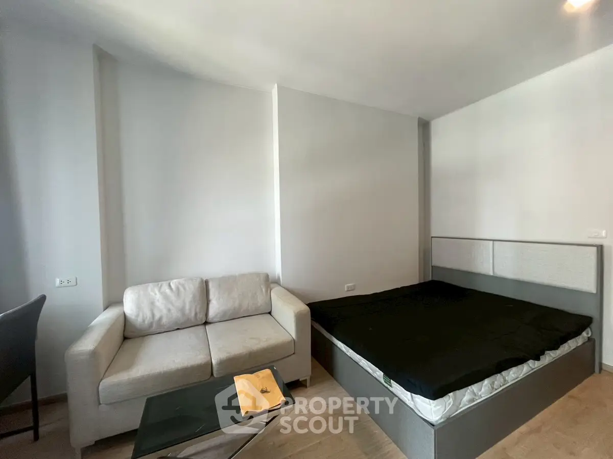 Modern studio apartment with cozy sofa and bed, perfect for urban living.