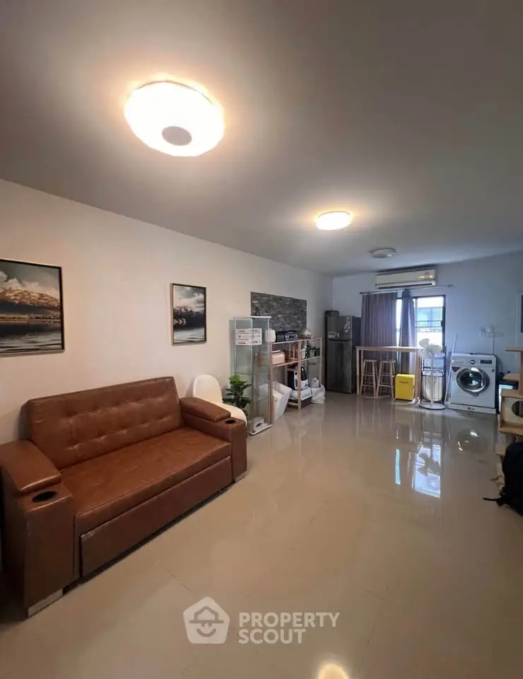 Spacious living room with modern furniture and appliances, perfect for comfortable living.