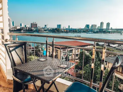 Stunning balcony view overlooking river and city skyline, perfect for relaxation and dining.