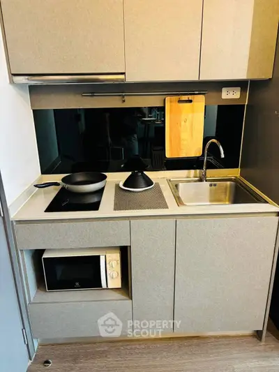 Modern compact kitchen with sleek cabinetry and built-in appliances, perfect for urban living.