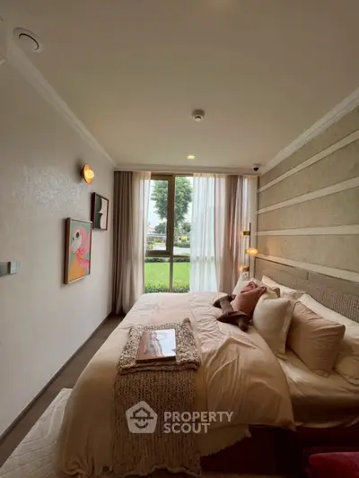 Cozy bedroom with large window and stylish decor, offering a serene garden view.