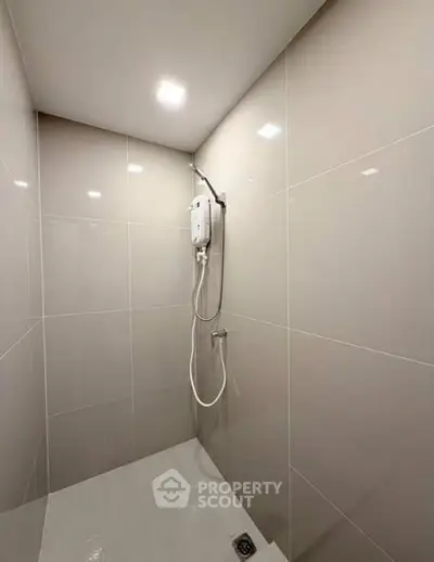 Modern minimalist bathroom with sleek tiled walls and built-in shower system.
