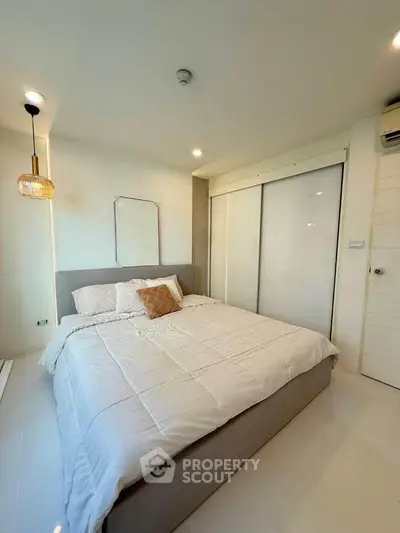 Modern bedroom with cozy bed and stylish lighting in a bright apartment.