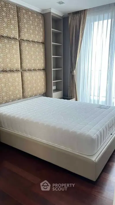 Luxurious bedroom with elegant decor and natural light, featuring a plush bed and stylish shelving.