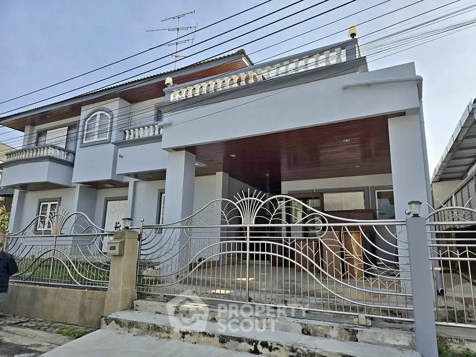 Elegant modern house with stylish metal gate and spacious balcony.