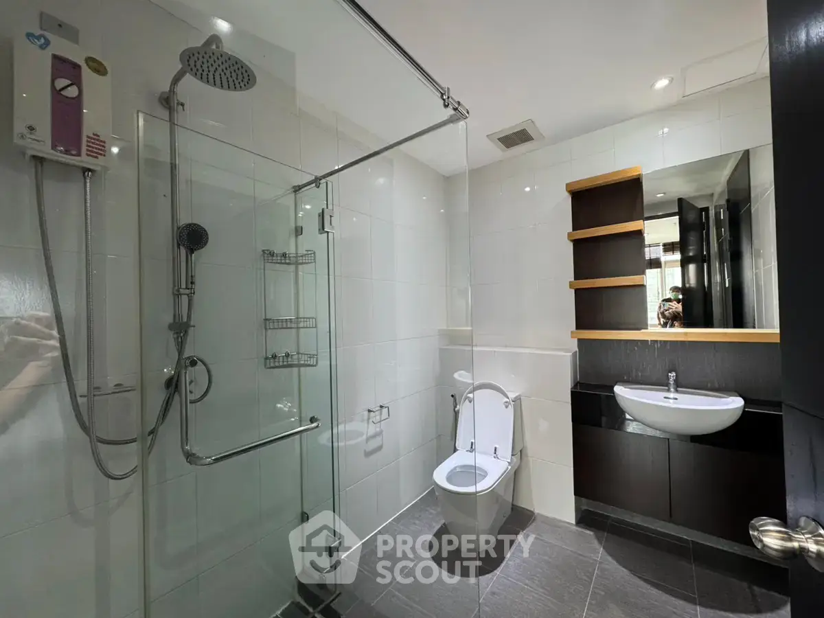 Modern bathroom with glass shower and sleek fixtures in a contemporary apartment.