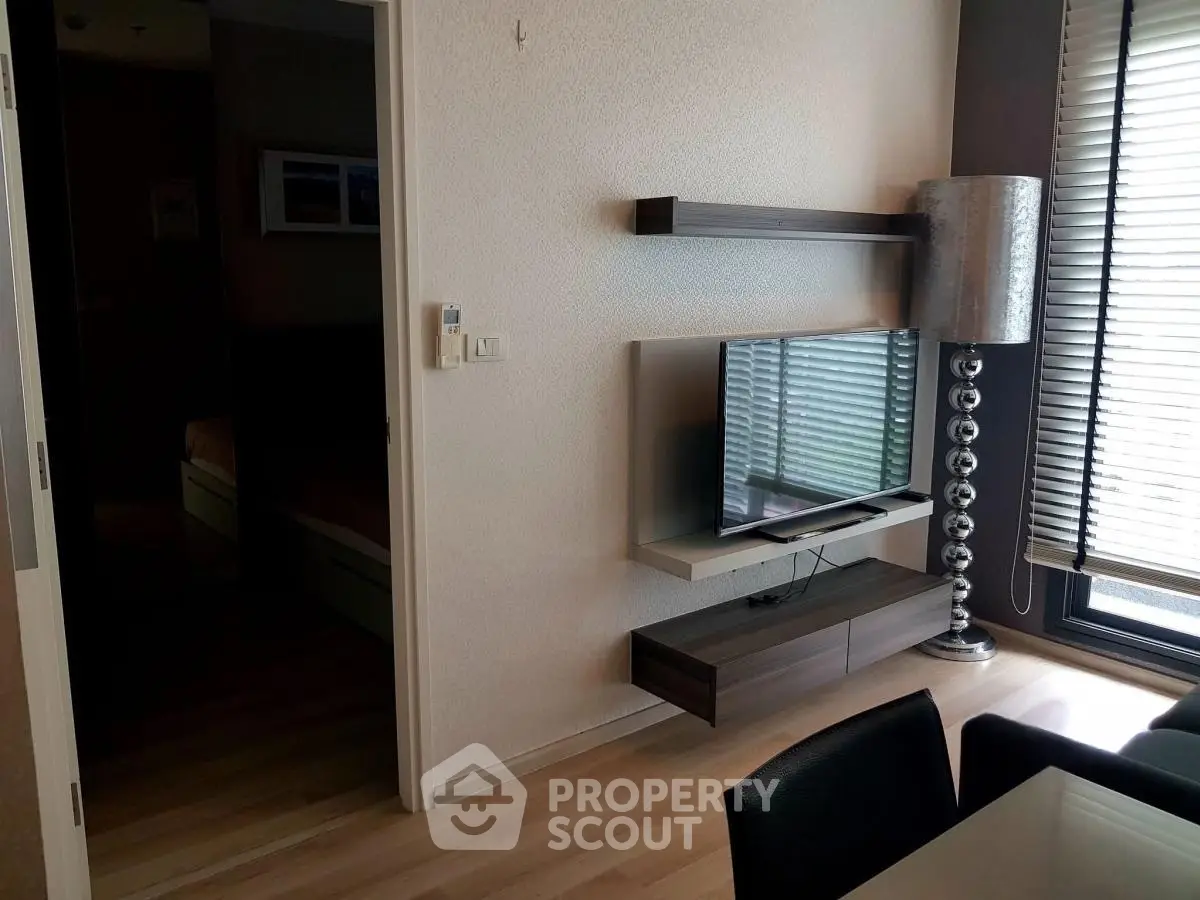 Modern living room with sleek TV setup and stylish floor lamp