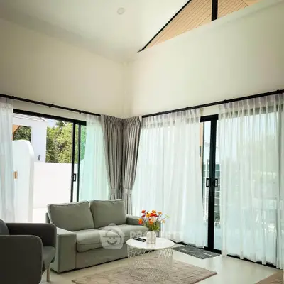 Spacious living room with modern decor and large windows for natural light.