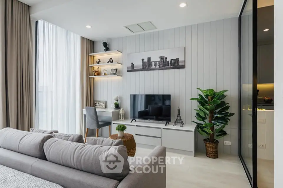 Modern living room with stylish decor, large window, and cozy seating area in a contemporary apartment.