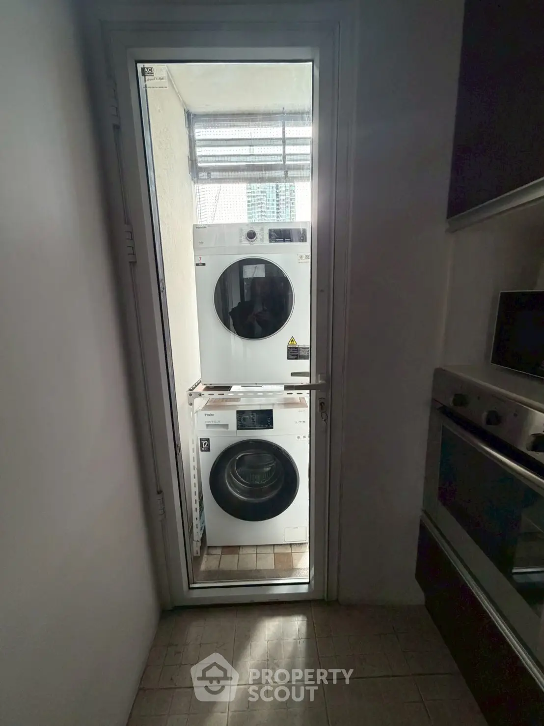 Compact laundry area with stacked washer and dryer in modern apartment.