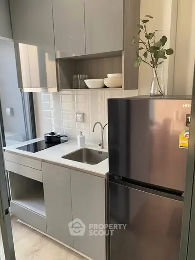 Modern compact kitchen with sleek cabinets and stainless steel appliances