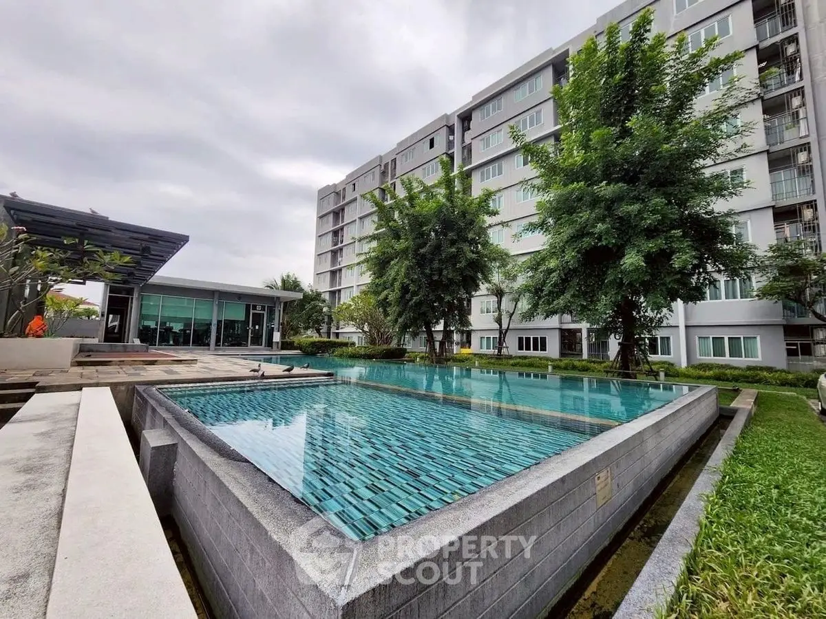 Modern apartment complex with luxurious pool and lush greenery