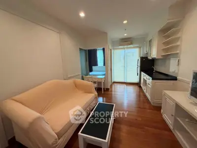 Charming open-layout living room with cozy sofa and modern kitchen in a stylish apartment.