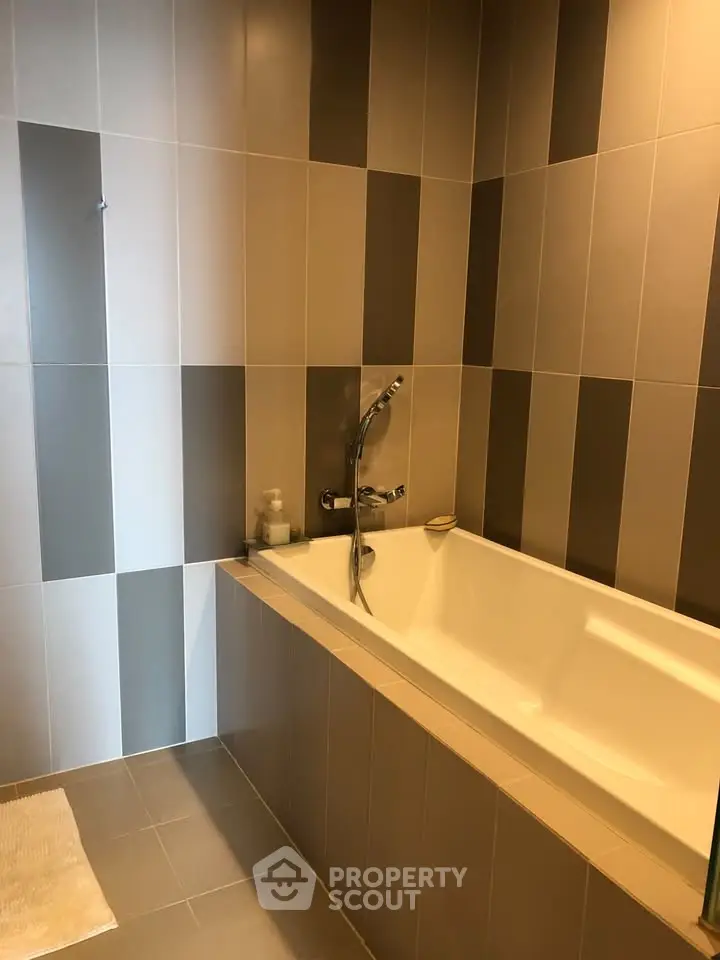 Modern bathroom with stylish tile design and built-in bathtub, perfect for relaxation.