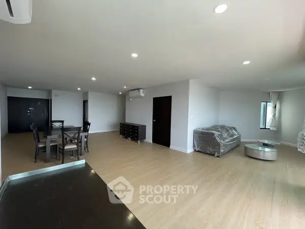 Spacious modern living room with dining area and sleek furnishings.