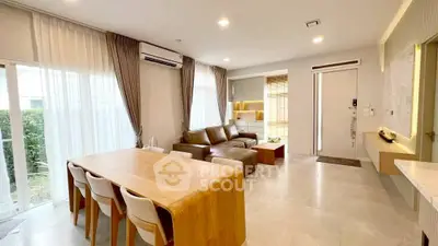 Spacious modern living room with elegant dining area and natural light.