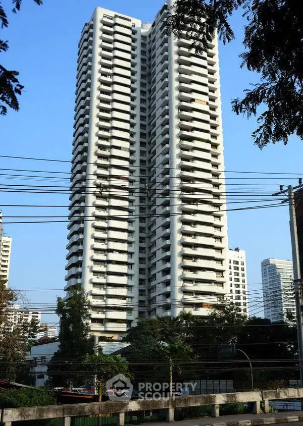 Stunning high-rise residential building with modern architecture and lush surroundings.