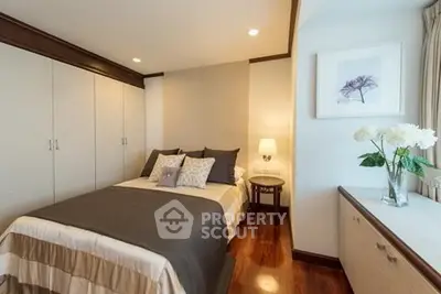 Cozy bedroom with elegant decor and ample storage space, featuring a comfortable bed and stylish lighting.