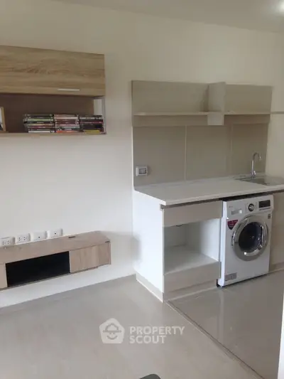 Modern kitchen with washing machine and sleek cabinetry in a compact layout.