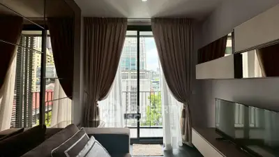 Modern living room with floor-to-ceiling windows and city view balcony.