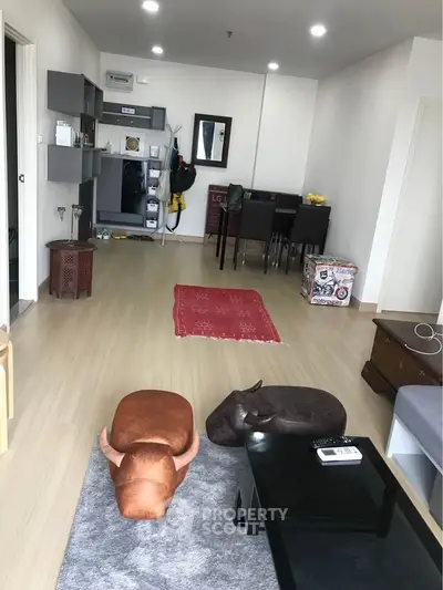 Spacious living room with modern decor and open layout, featuring stylish furniture and ample natural light.