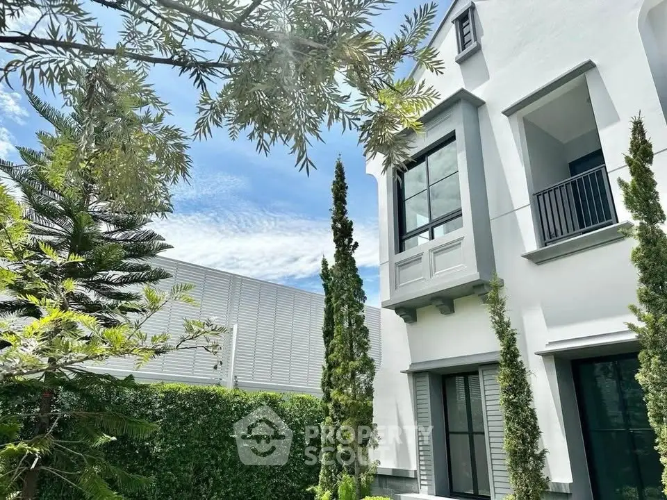 Modern two-story house with lush garden and elegant facade