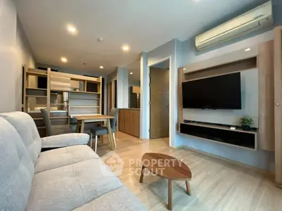 Modern living room with stylish furniture and wall-mounted TV in cozy apartment