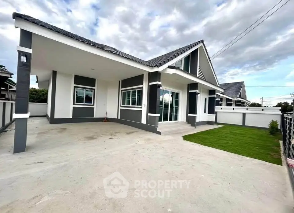 Modern single-story house with spacious driveway and manicured lawn