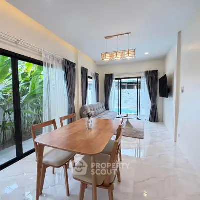 Modern living room with elegant dining area and large windows overlooking lush greenery.