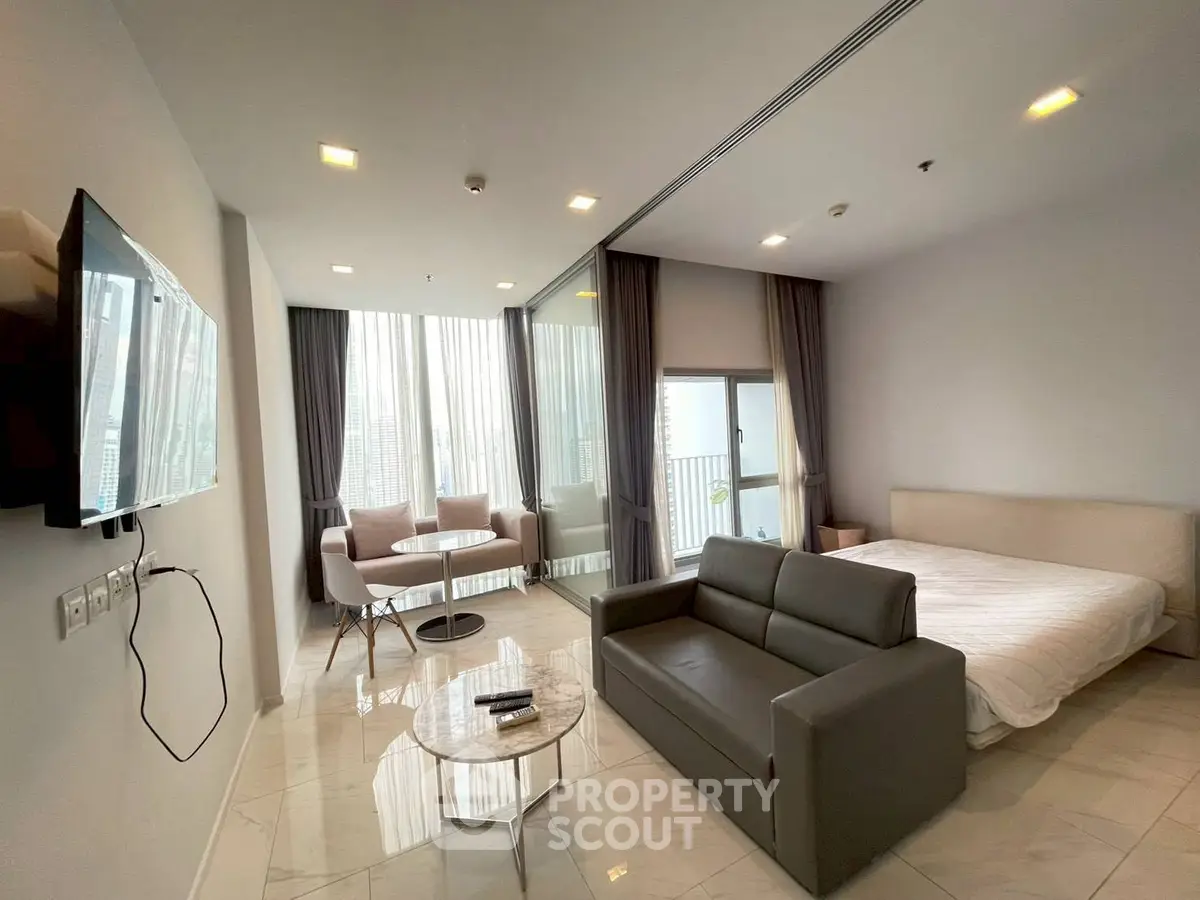 Modern studio apartment with sleek furniture and large windows offering city views.