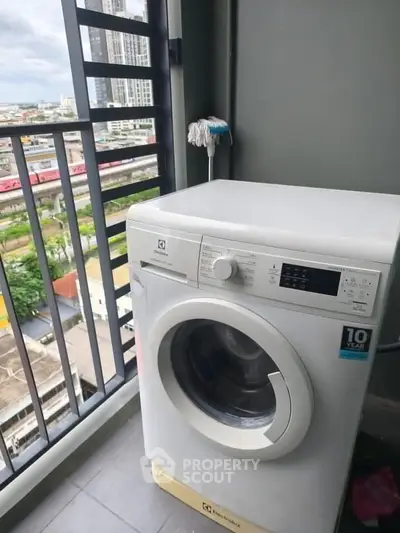 High-rise balcony with washing machine and city view, perfect for urban living convenience.