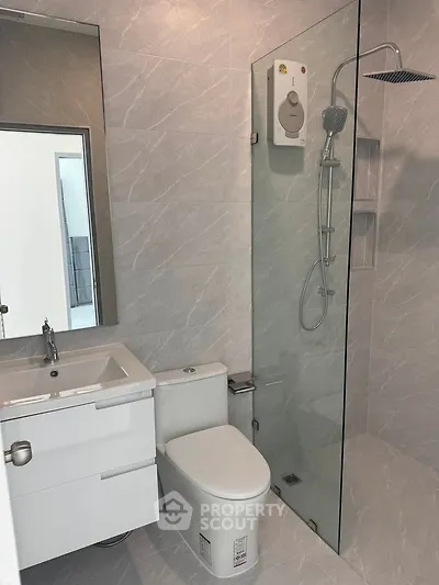 Modern bathroom with sleek shower and stylish vanity in contemporary apartment.