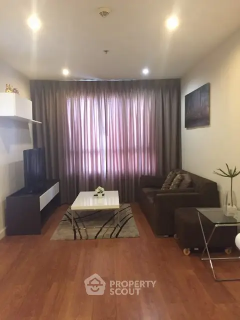 Modern living room with cozy sofa, stylish coffee table, and elegant curtains in a well-lit space.