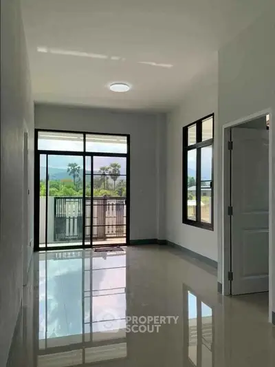 Spacious modern living room with large windows and balcony access, offering stunning natural light and views.