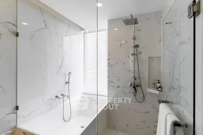 Luxurious modern bathroom with marble finishes and sleek shower design.