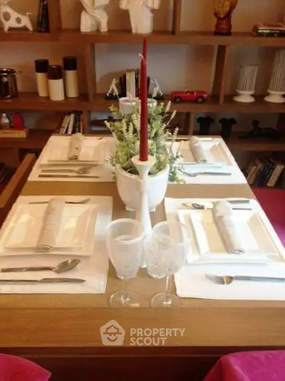 Elegant dining table setup with stylish decor and shelving in background