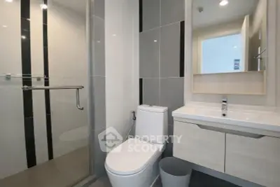 Modern bathroom with sleek design, featuring a glass shower and contemporary fixtures.