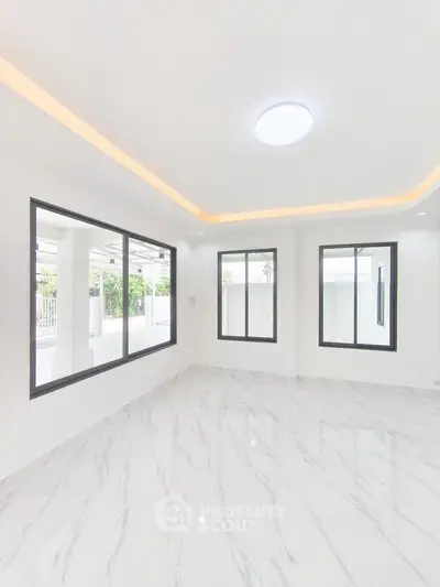 Bright and modern living room with large windows and marble flooring