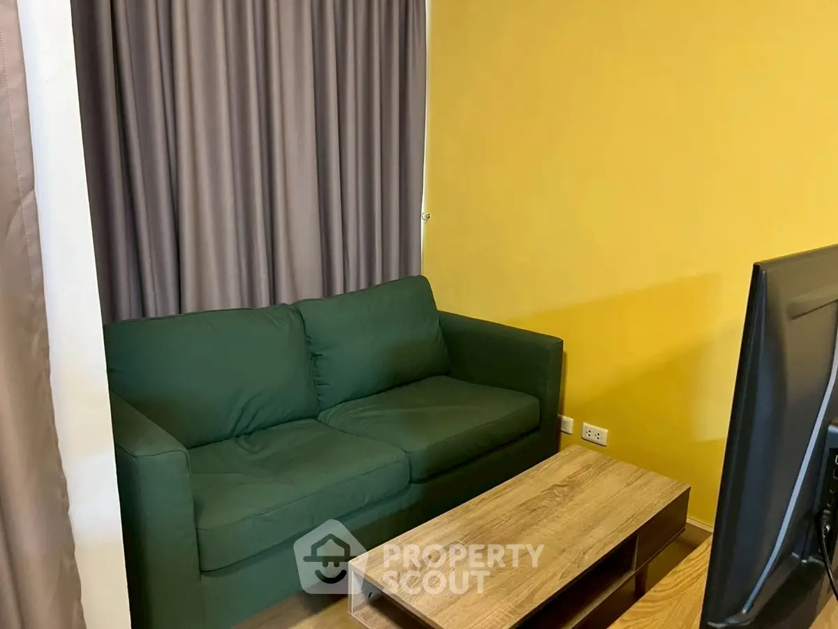 Cozy living room with green sofa and wooden coffee table, perfect for relaxation.