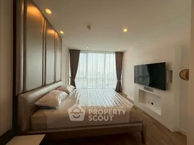 Modern bedroom with large window and city view, featuring a wall-mounted TV and stylish decor.