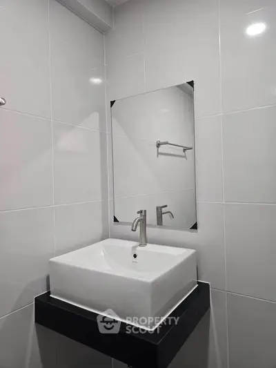 Modern bathroom with sleek white sink and minimalist design.
