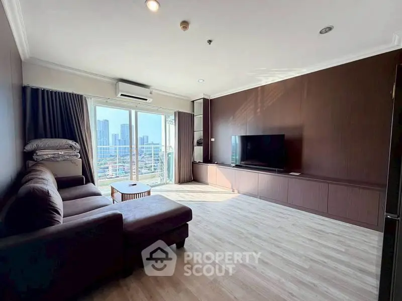 Spacious living room with city view, modern furniture, and natural light.
