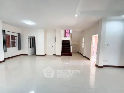 Spacious open-plan living area with staircase and natural light