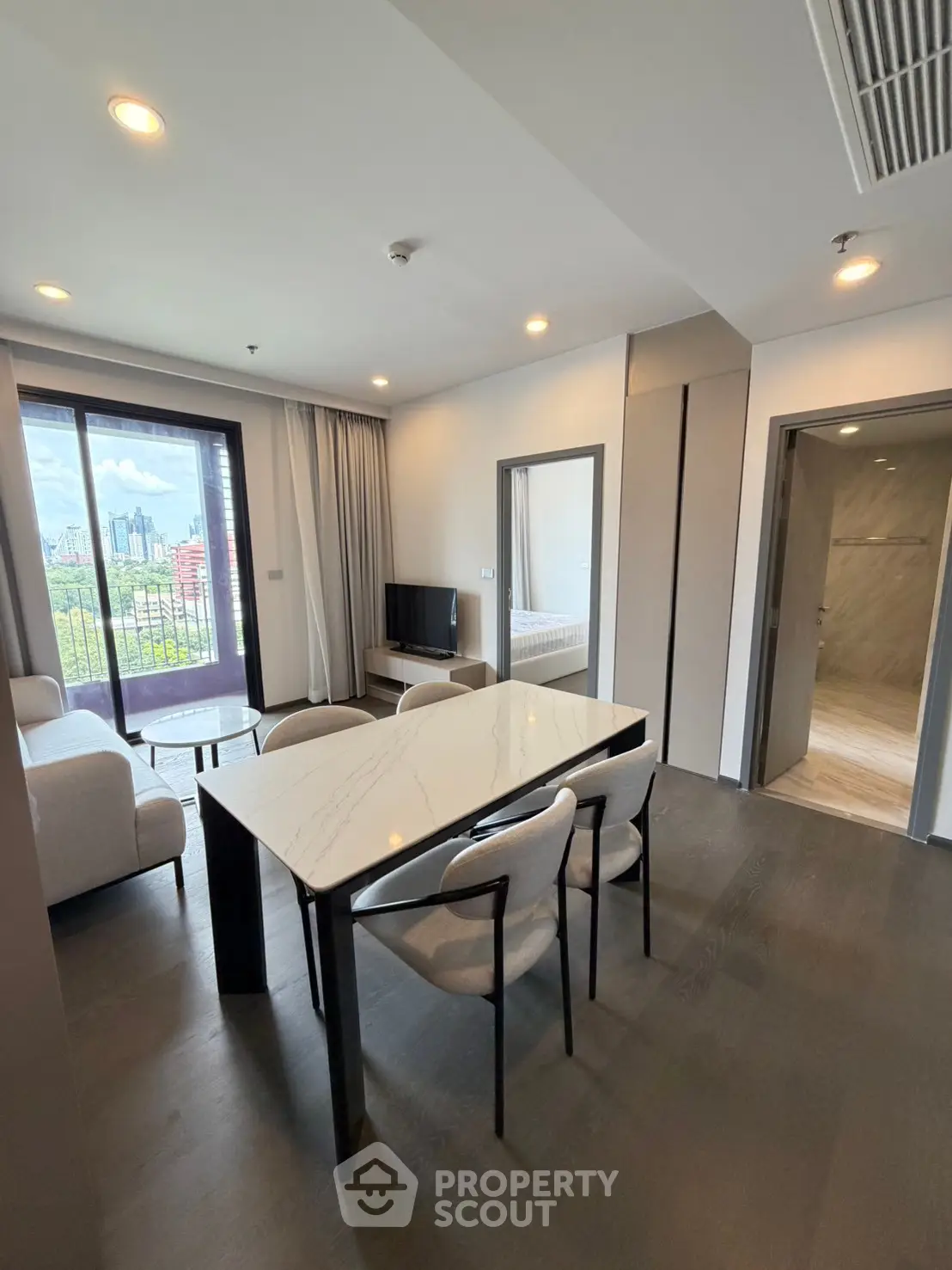Modern living room with elegant dining area and city view balcony in luxury apartment