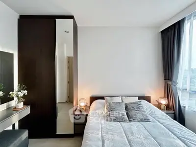 Modern bedroom with sleek design and large window offering city views.