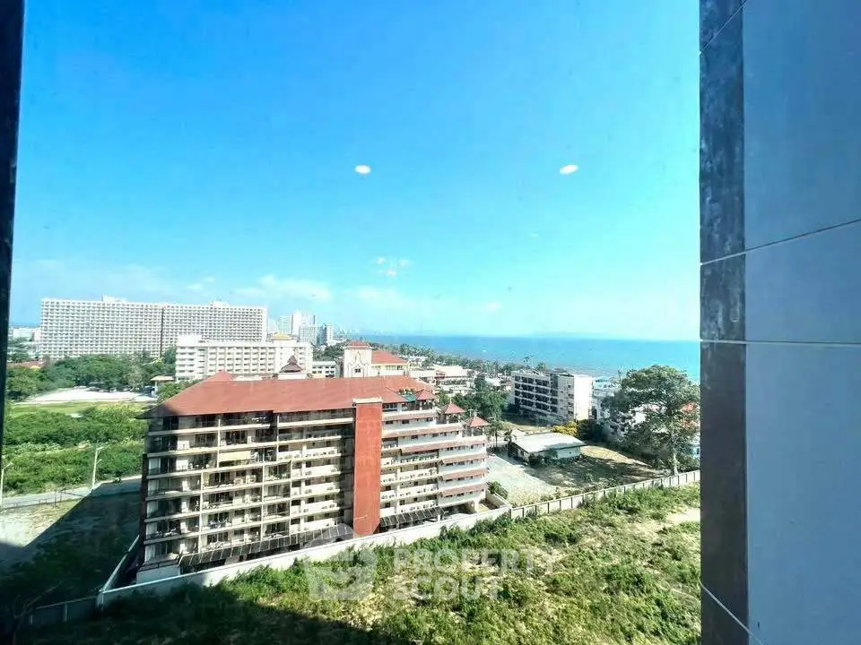 Stunning ocean view from high-rise building window, showcasing coastal urban landscape.