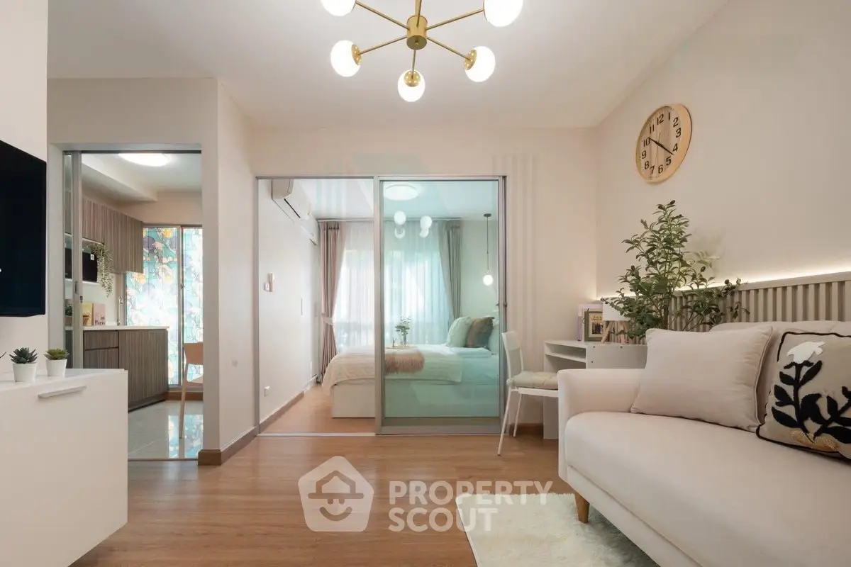 Modern living room with elegant decor and sliding glass doors leading to a cozy bedroom.