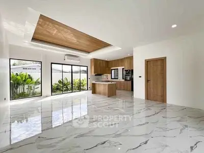 Spacious modern kitchen with marble flooring and wooden ceiling accents, featuring large windows and open layout.